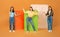 Joyful women posing with huge shopping bags on orange background