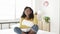 Joyful young african american woman dancing while listening to music on bedroom