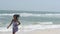 Joyful young Asian woman at the beach enjoying the wind, turning around happily.