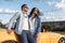 Joyful young couple staying beside a yellow convertible car. Freedom, travel and love concept.