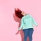 Joyful young fatty woman in glasses with flowing red hair smiling while jumping on place.