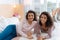 Joyful young ladies beaming while relaxing on bed