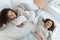 Joyful young ladies taking break and lying on bed