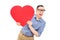 Joyful young man holding a big red heart