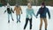 Joyful young people enjoying double date at ice skating rink talking laughing having fun