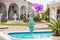 Joyful young woman jumping into the pool while holding a bunch of balloons