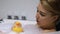 Joyful young woman playing with rubber duck in bath and laughing, good mood