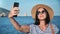 Joyful young woman posing taking selfie use smartphone at seaside. Close up shot on 4k RED camera