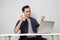 joyfull happy asian man at workplace while sitting in front of laptop computer. on isolated background