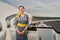 Joyous air hostess in uniform standing by the landed aircraft