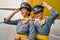 Joyous air hostesses in uniforms by a landed aircraft