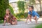 Joyous children drawing with colored chalks on the ground