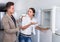 Joyous couple choosing new refrigerator in hypermarket