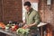 Joyous dark-haired male preparing a healthy salad