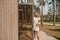 Joyous female cleaning the outside of a wooden house