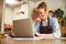 Joyous focused woman reading an email on her laptop