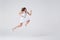 Joyous girl jumping up in air over background in studio