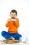 Joyous kid eating chocolate sitting cross-legged