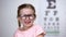 Joyous little girl in eyeglasses laughing, positive vision treatment results
