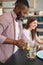 Joyous man preparing herbal beverage for two