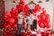 Joyous moment between young couple celebrating with toast Valentines day near red balloons