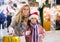Joyous mother with little daughter buying decorations for Xmas at an market