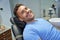 Joyous patient of dental clinic resting in dental chair