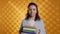 Joyous person walking with pile of novels, feeling delighted, studio background