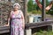 Joyous senior woman standing near house wall