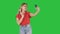 Joyous woman 30s wearing red t-shirt taking selfie photo while walking on a Green Screen, Chroma Key.