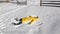 Joyous Woman is Playing in Winter Game. Girl in Bringh Yellow Jacket is Lying on the Ground and Making Snow Angel Having