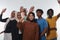A jubilant and diverse group, including an African American man and hijab-wearing girls, exuberantly wave and celebrate