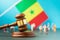 Judge gavel against the background of a blurred flag and plastic toy men, the concept of litigation in Senegalese society