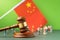 Judge gavel against blurry flag background and toy plastic men, concept of litigation in China