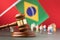 Judge gavel on blurred Brazilian flag background and plastic toy men, Brazilian society litigation concept