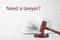 Judge gavel, book and text NEED A LAWYER? on background