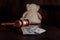 Judge gavel, dollar banknotes and teddy bear on a wooden table. Divorce and alimony concept