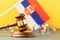 Judge gavel, flag and plastic toy men on colored background, Serbia litigation concept