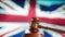 A judge gavel with a flag of United Kingdom on background. Close up of wooden hammer and legal lawyer books or codex