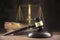 Judge gavel, old books and scales on a wooden table, justice symbols for balance and power in law and court, dark background with