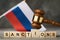 Judge gavel, wooden cubes with the text on the background of the Russian flag, the concept on the topic of sanctions in Russia