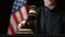 Judge hammering with wooden gavel against American flag in United States court room