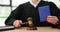 Judge hits gavel on sound block holding passport in hand