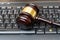 A judge presides over a court, brandishing the mace of justice while a laptop and keyboard display evidence in an ongoing