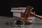 Judge`s gavel, handcuffs and books on table against black background. Criminal law concept