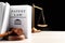 Judge`s gavel, Patent Law book and scales on white table against black background. Space for text