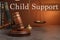 Judge`s gavel, scales of justice and books on wooden table. Child support concept