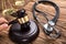 Judge`s Hand Hitting Mallet By Stethoscope And Justice Scale
