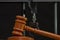 The judge`s wooden hammer for sentencing against the background of bars and handcuffs. Concept: court session, trial, sentencing.