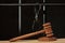 The judge`s wooden hammer for sentencing against the background of bars and handcuffs. Concept: court session, trial, sentencing.